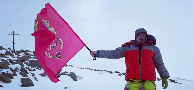 Запорожец развернул флаг города на вершине горы в Киргизии