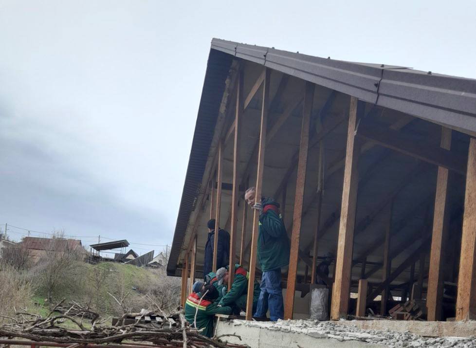 Коммунальщики чинят крышу дома, который пострадал от ракетного удара в Запорожье. ФОТО